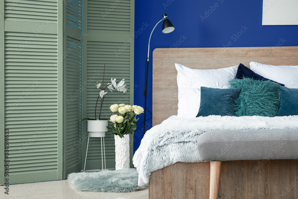 Interior of modern bedroom with blue wall