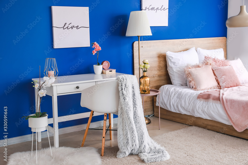 Interior of modern bedroom with blue wall