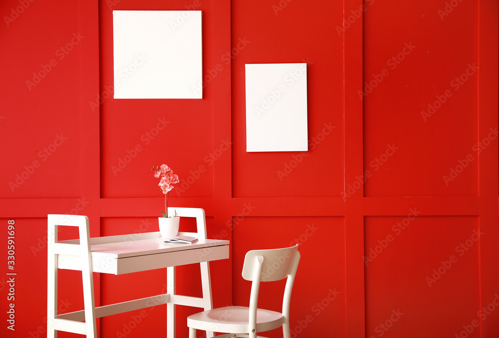 Stylish table with chair near color wall