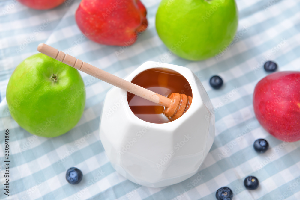 Tasty honey with fruits on table