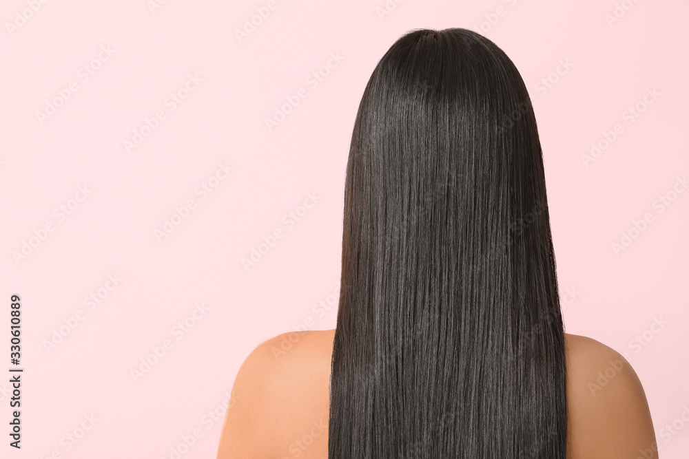 Young Asian woman with beautiful long hair on color background