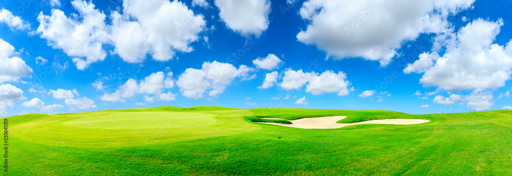 Green golf course and blue sky with white clouds,panoramic view.