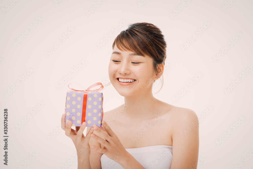 A portrait of beautiful girl holding a gift box isolated on white background