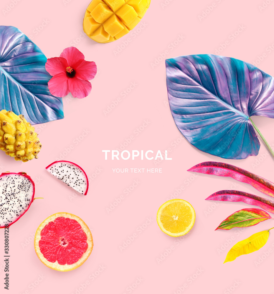 Creative layout made of grapefruit, lemon, dragonfruit, mango and tropical leaves and flowers on the