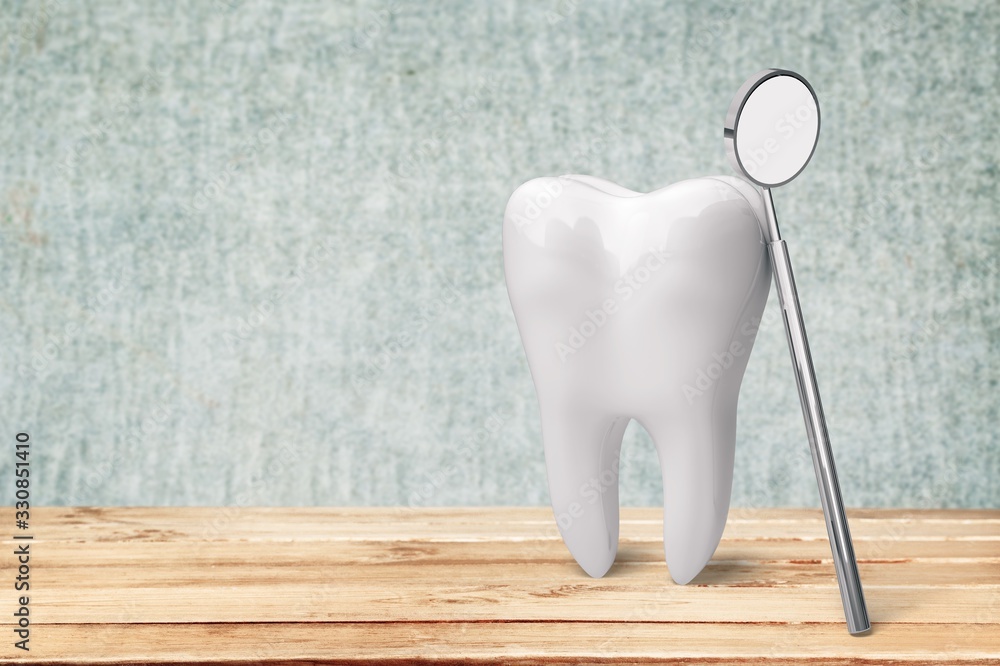 Big tooth and dentist mirror on desk