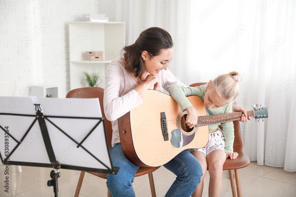 私人音乐老师在家给小女孩上吉他课