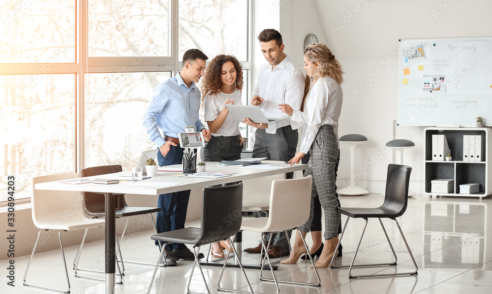 Male interior designer teaching young people in office