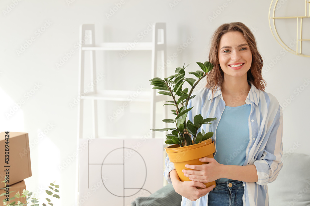 Happy young woman with belongings in her new home