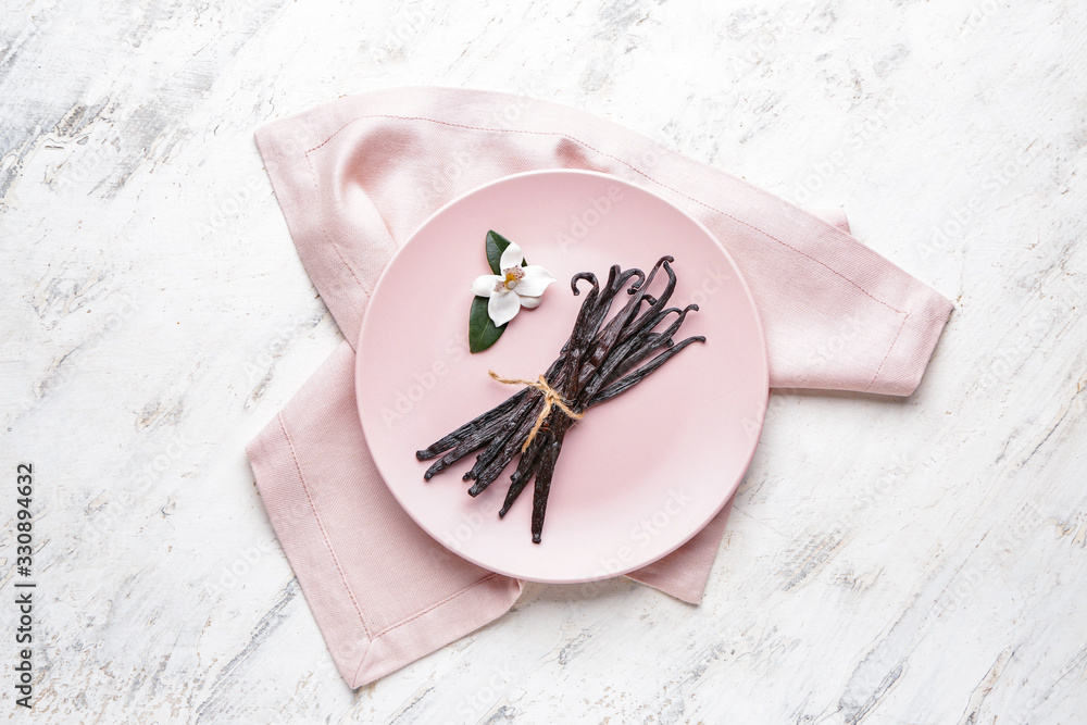 Plate with aromatic vanilla sticks on light background