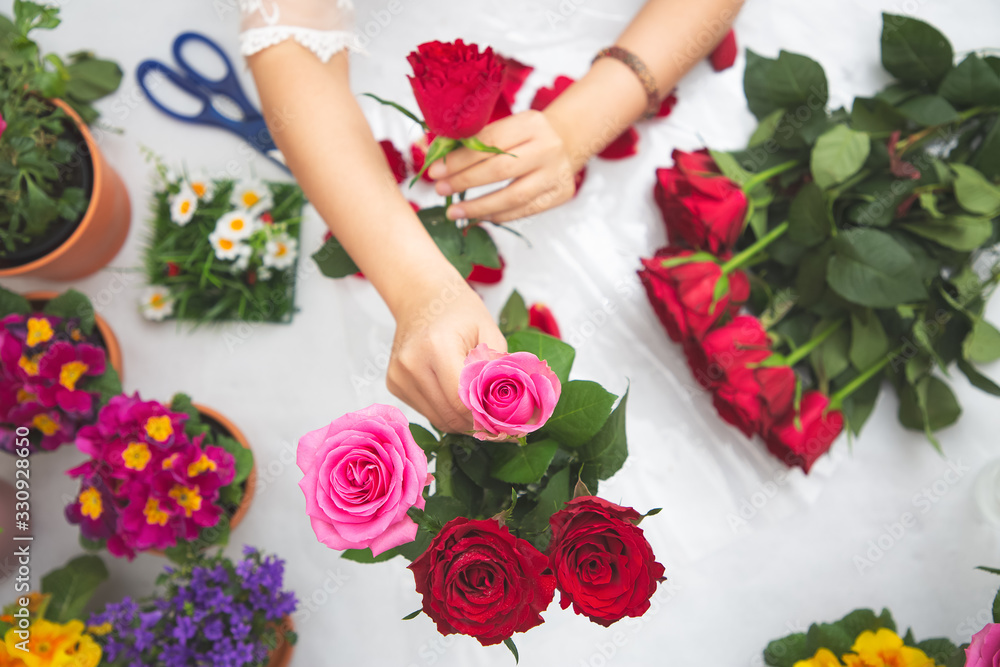 Woman Preparing to trim red and pink roses and beautiful flower arrangements in the home, flower arr