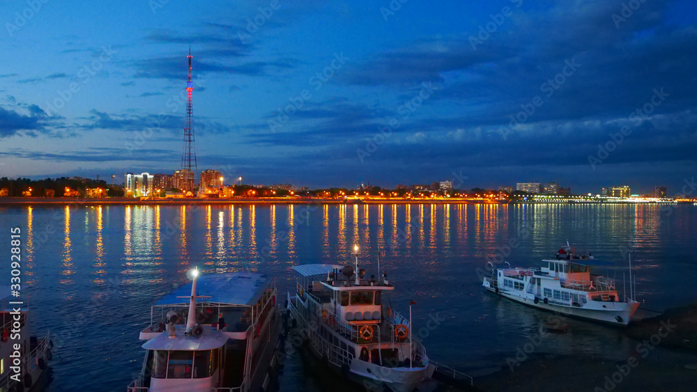 City skyline during nighttime: City lights and ships decorated with lights