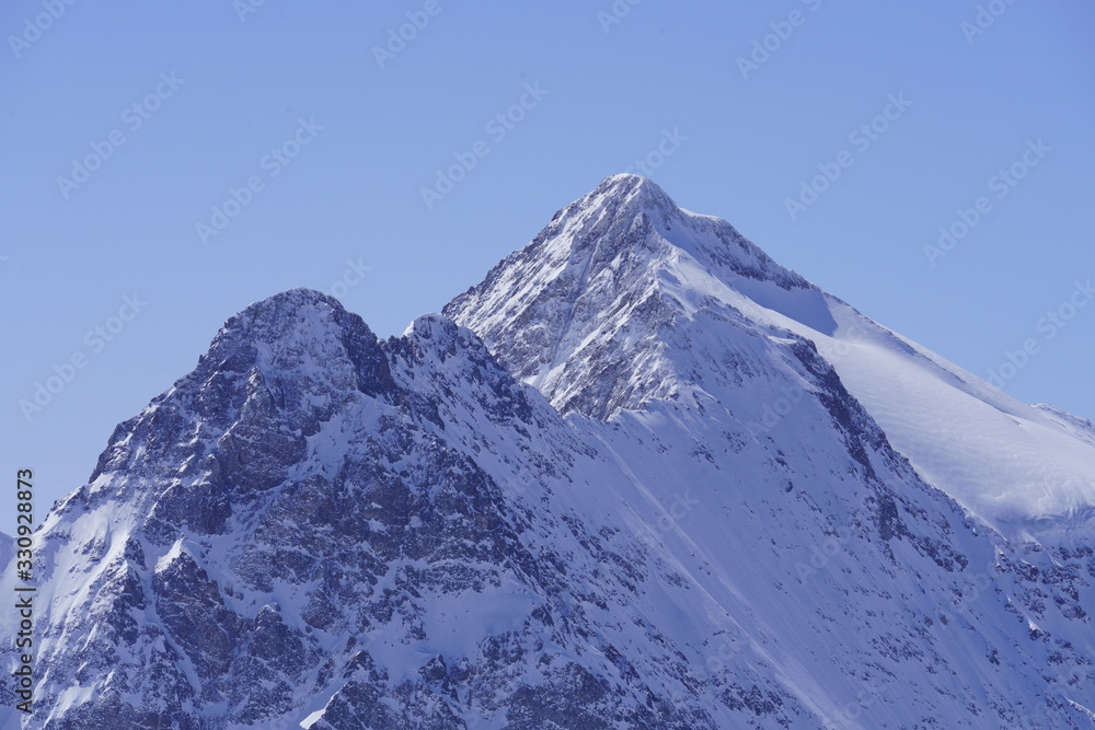 Close-up of snow-covered mountain peaks and blue sky