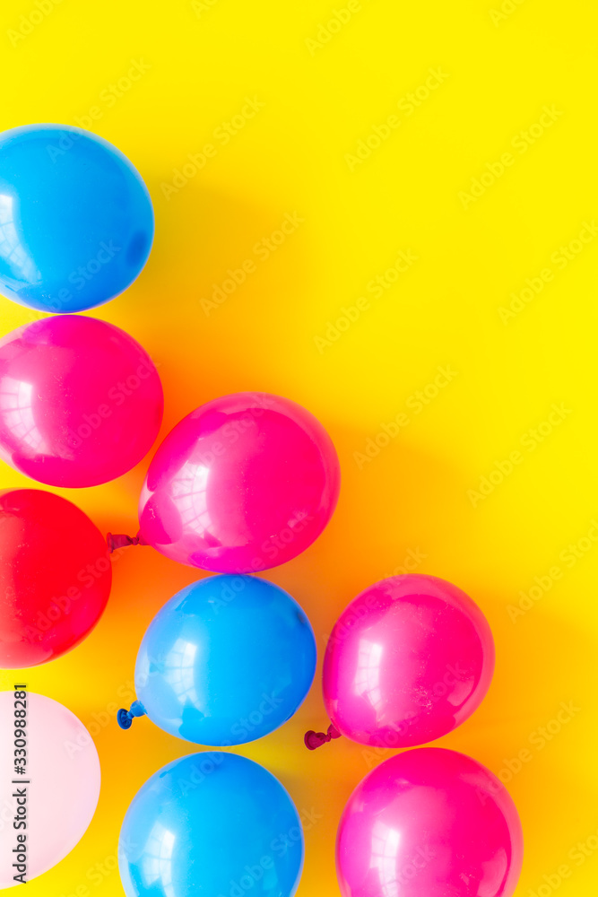 Colorful balloons frame on yellow background top-down frame copy space