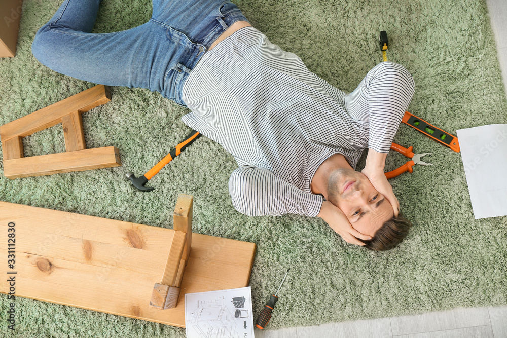 压力重重的男人在家组装家具，俯视图