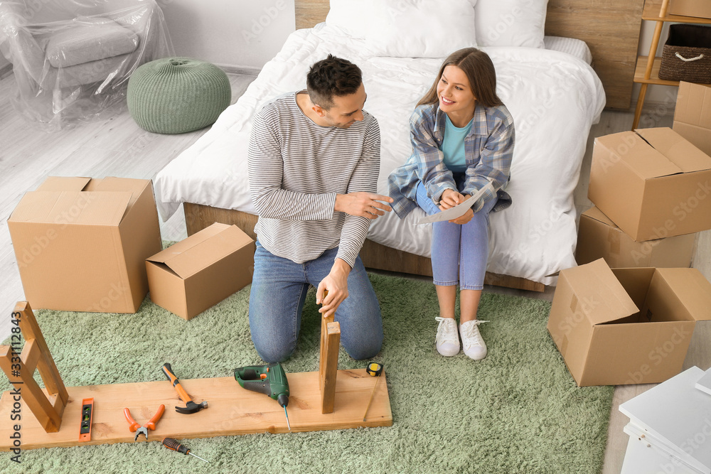 Young couple assembling furniture at home