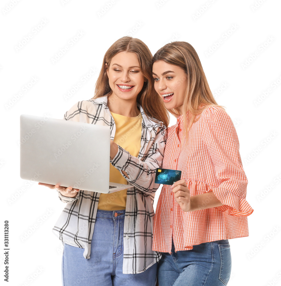 Young women with laptop and shopping bags on white background