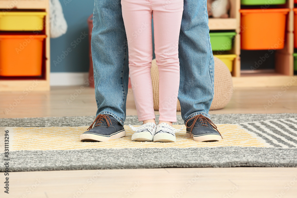 Legs of happy father and his little daughter at home