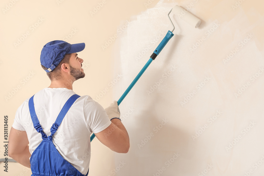 Male painter doing repair in room