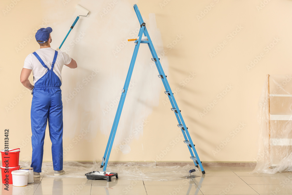 Male painter doing repair in room