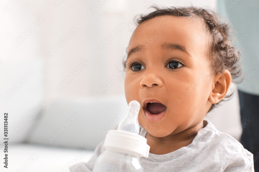 African-American baby with bottle of water at home