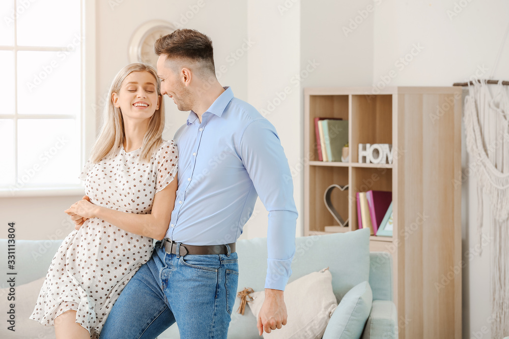 Happy dancing young couple at home