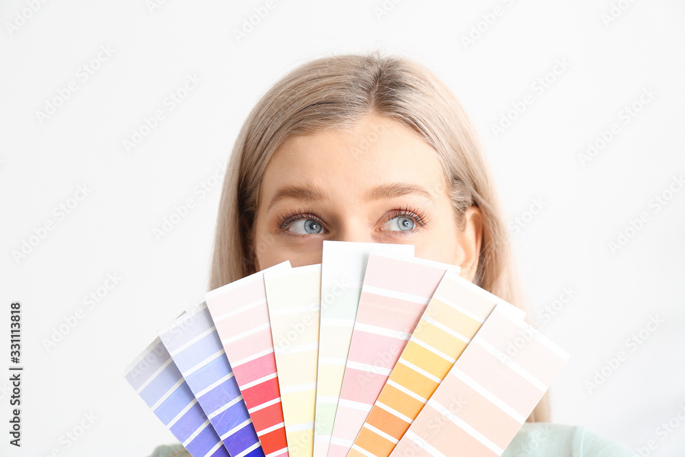 Young woman with color swatches on white background