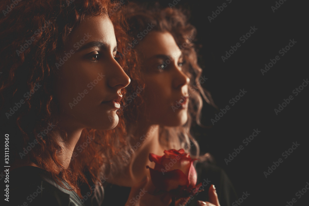 Beautiful young women with flower on dark background