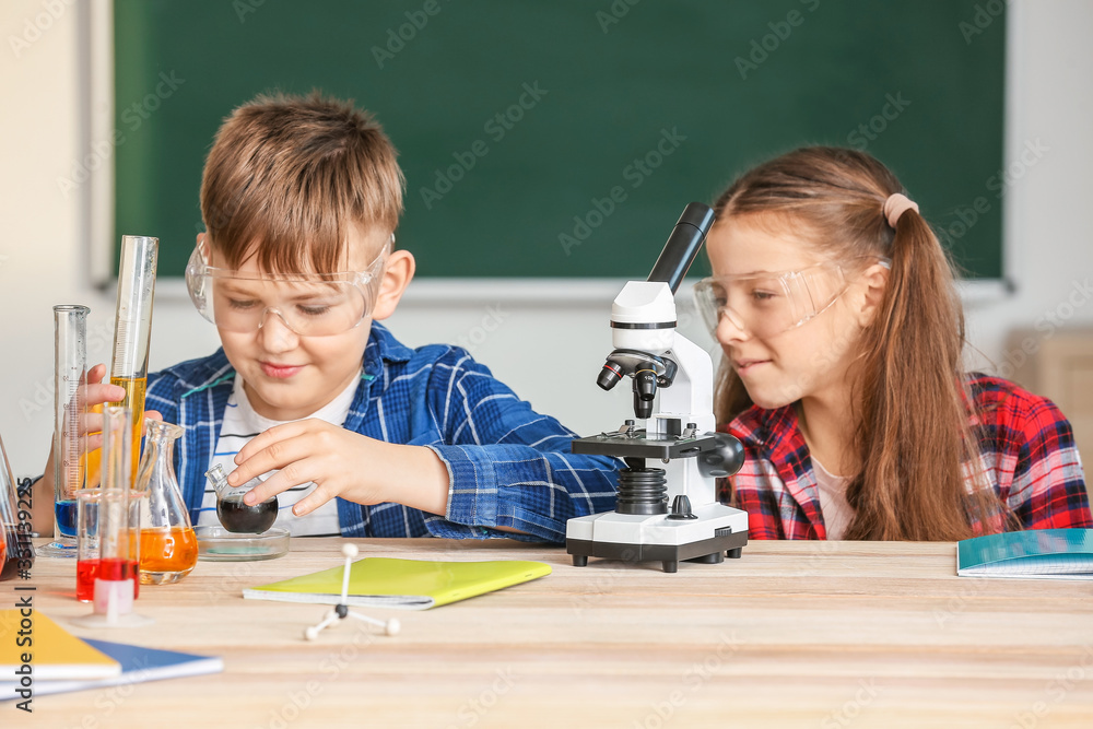 Cute little children at chemistry lesson in classroom