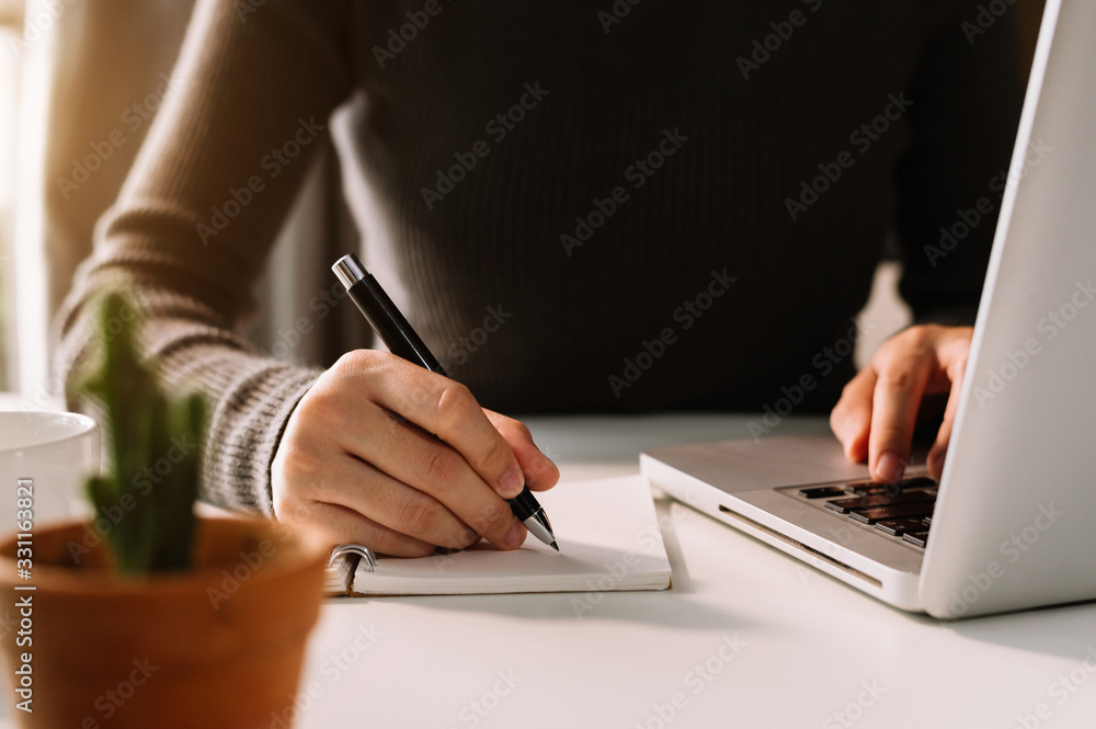 businessman hand working with new modern computer and writing on the notepad strategy diagram as con