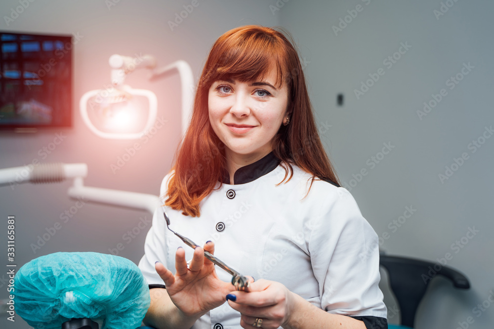 Beautiful young dentist woman posing in modern dental office. Medicine, health, stomatology concept.