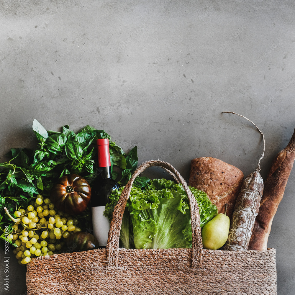 Flat-lay of healthy grocery shopping eco-friendly bag with vegetables, fruit, greens, bread, sausage