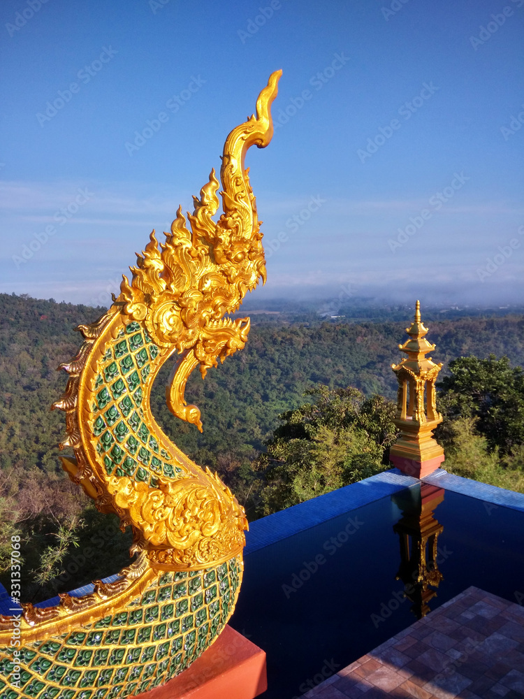 A beautiful golden serpent in a temple on a high mountain Overlooking the sea of ​​mist on clear sky