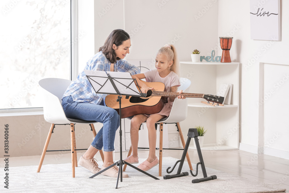 私人音乐老师在家给小女孩上吉他课