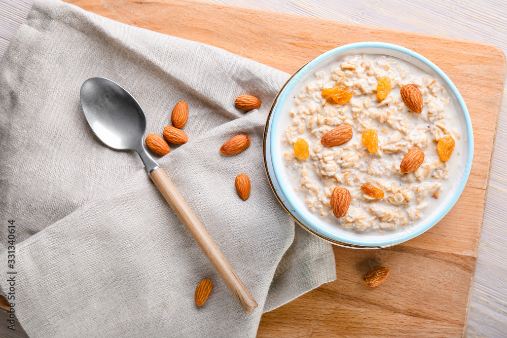 Bowl with tasty sweet oatmeal on table