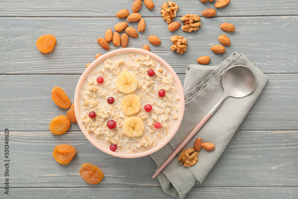 Bowl with tasty sweet oatmeal on table