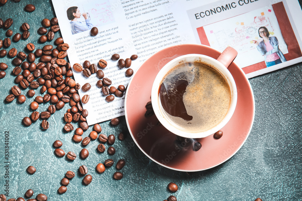 Cup of hot coffee and newspaper on table