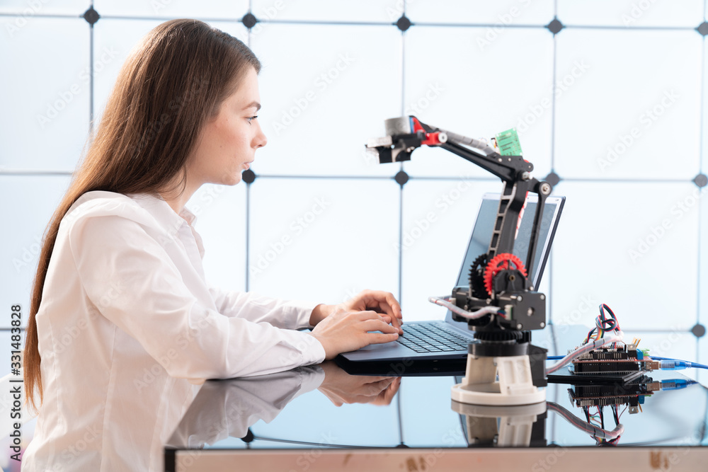 Woman student with robot model arm