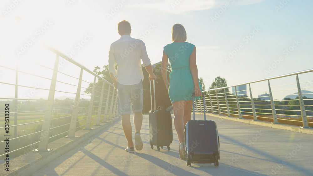 LENS FLARE: Golden sunbeams shine on newlyweds deciding to walk to the airport