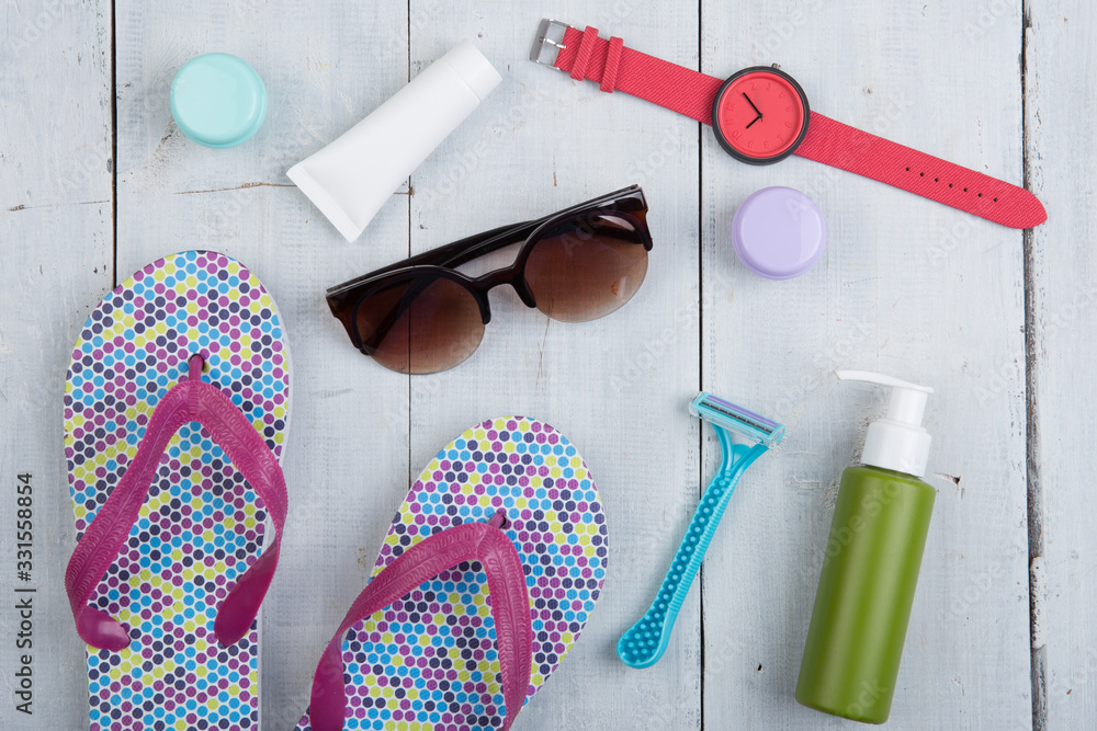 Travel concept - flip flops, swimsuit, sunglasses and sunblock, packaging for beach vacation