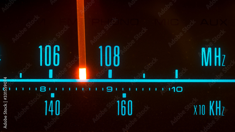 Classic radio tuner panel close-up. Black background