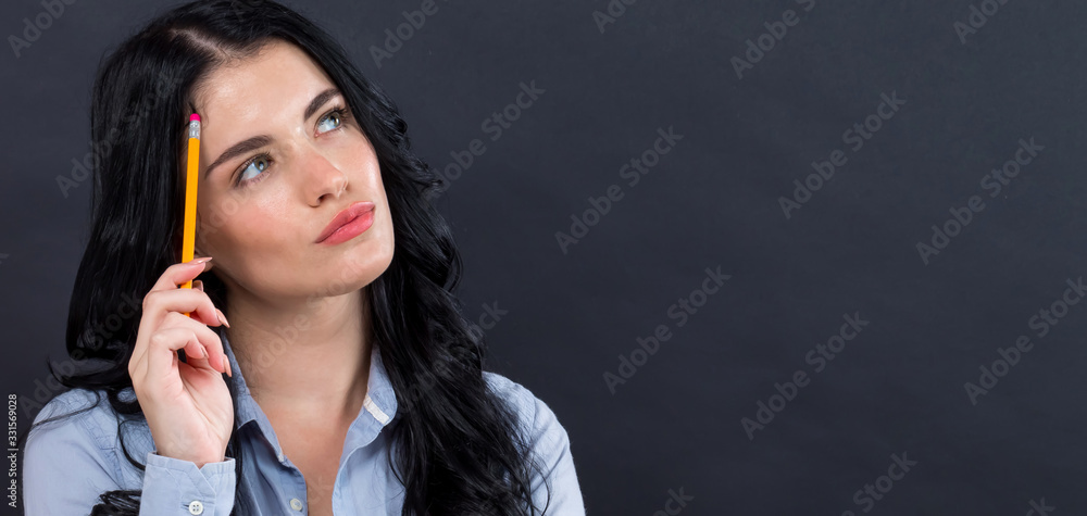 Young woman in a thoughtful pose on a black background