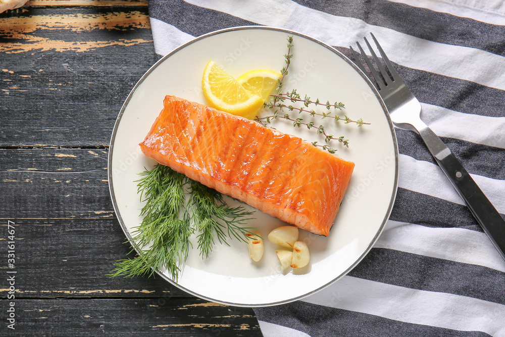 Cooked salmon fillet with herbs on table