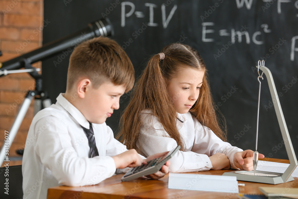 Cute little children at physics lesson in classroom