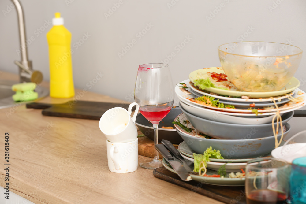 Pile of dirty dishes on kitchen table