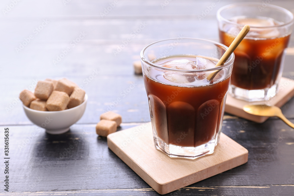 Glasses of tasty cold coffee and sugar on table