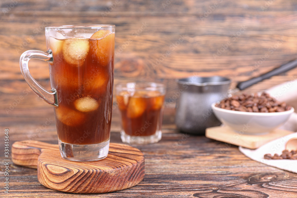 Glass of tasty iced coffee on table