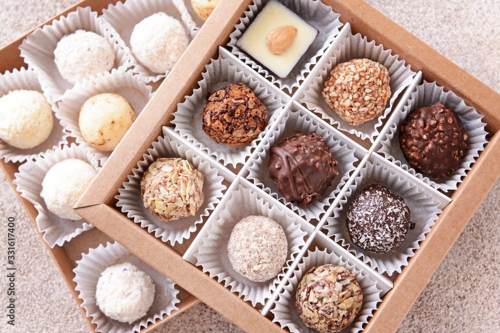 Boxes with delicious candies on grey background