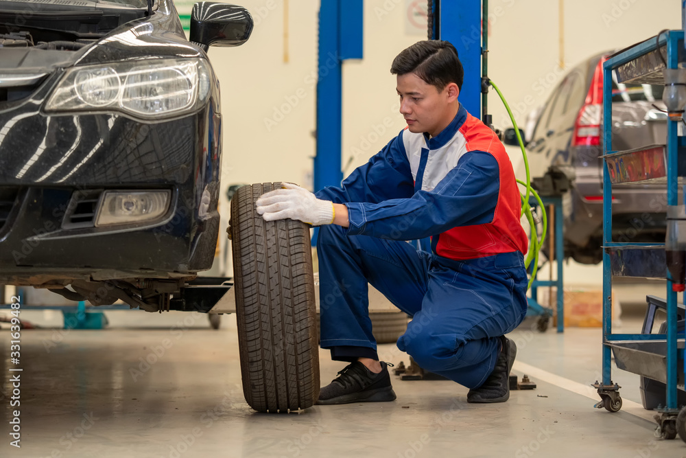 Car mechanic,mechanic change the tire at a service station,Car repair concept.