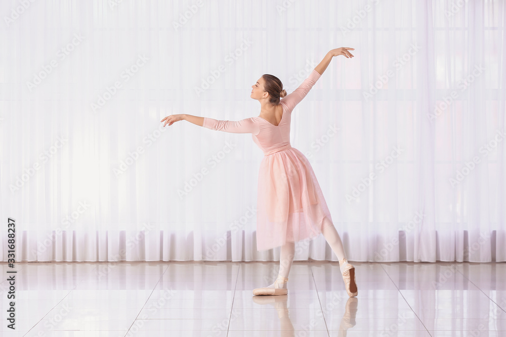 Beautiful young ballerina in dance studio