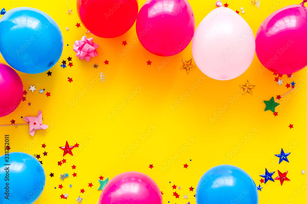 Party concept. Colorful balloons and confetti on yellow background top-down frame copy space